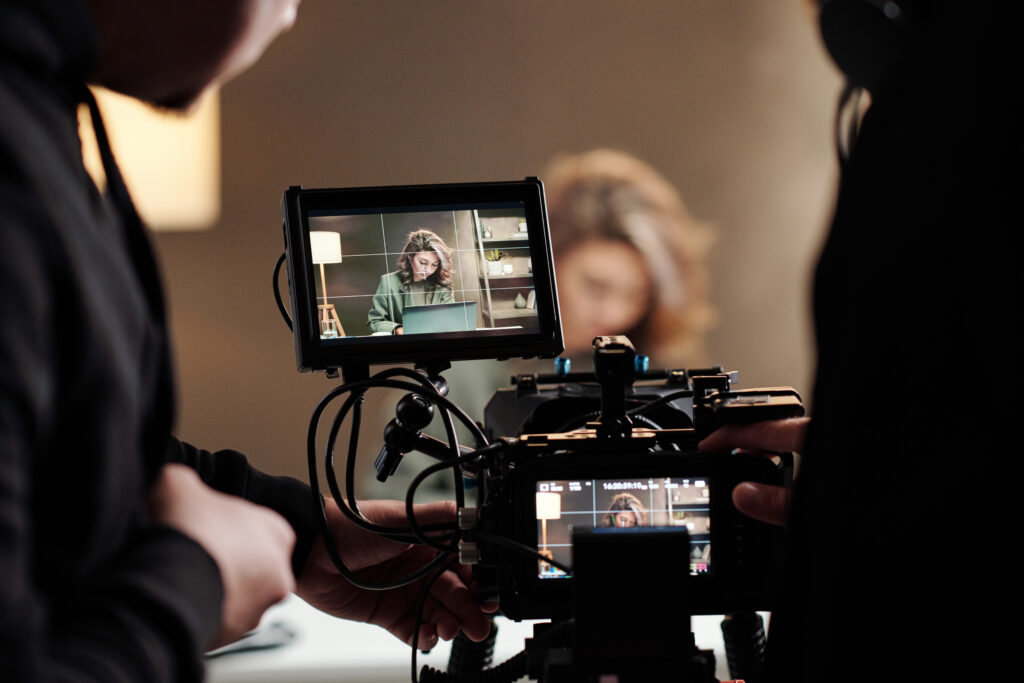 close up of steadicam screens with female model using laptop by table